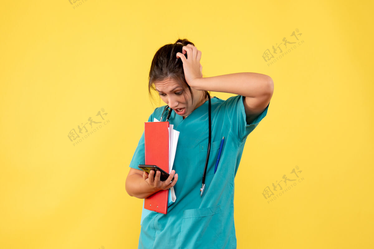 持有前视图穿着医疗衬衫的女医生拿着黄色背景上的分析和电话病毒黄色前面