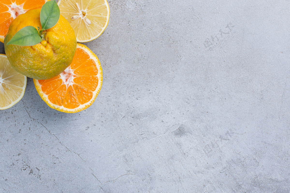 天然整个橘子放在柠檬上 橘子片放在大理石背景上美味新鲜美味