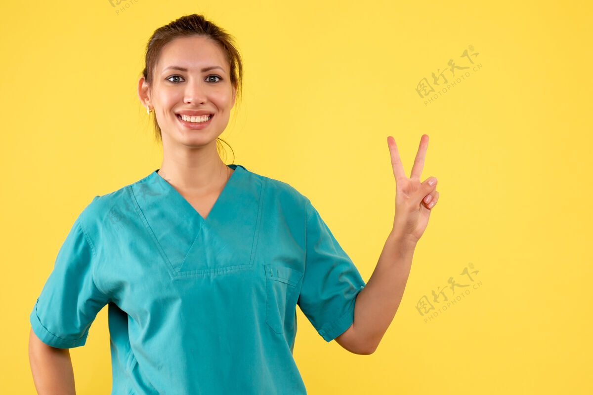 病毒前视图黄色背景上穿着医用衬衫的女医生黄色专业视图