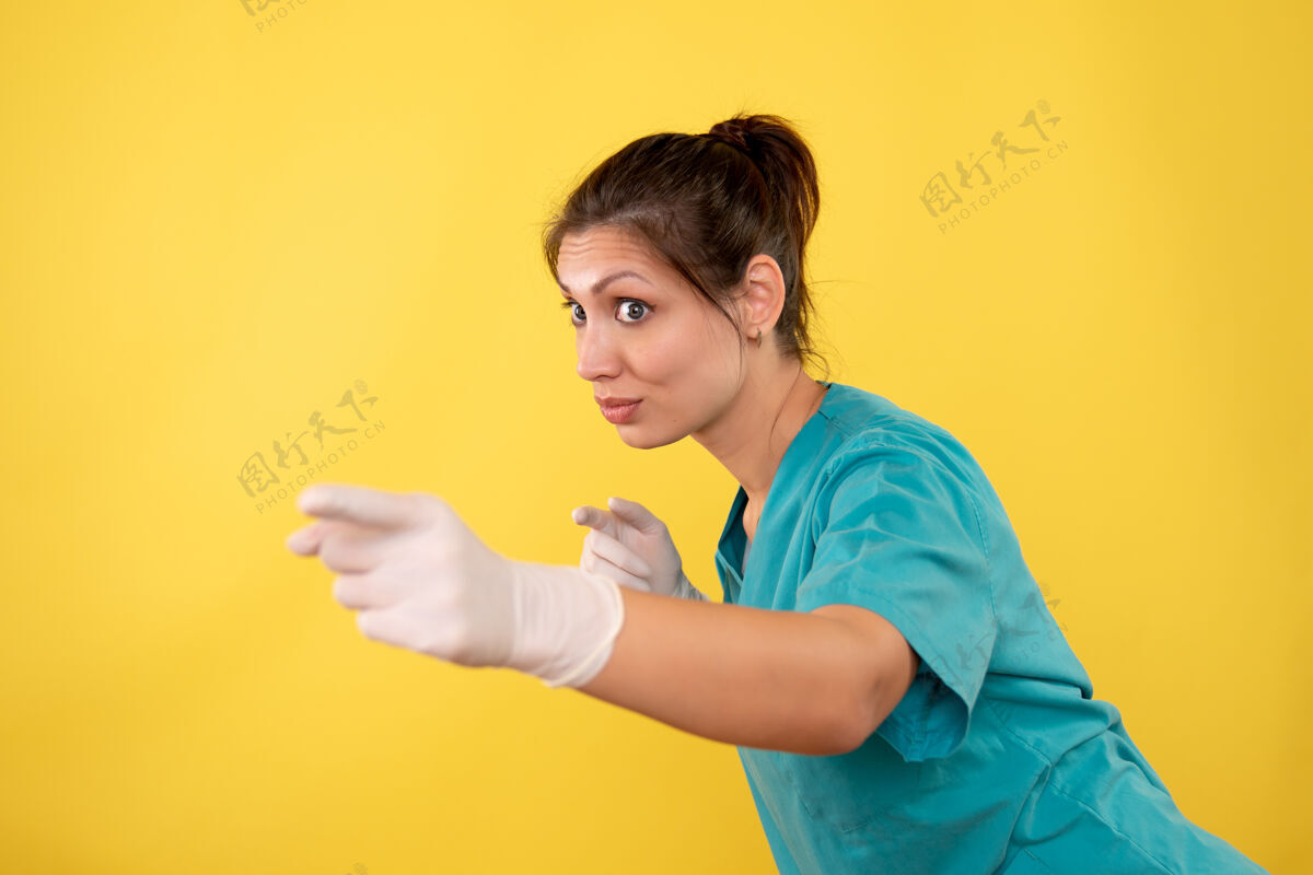 休闲前视图黄色背景上戴着医用手套的女医生视图护士黄色