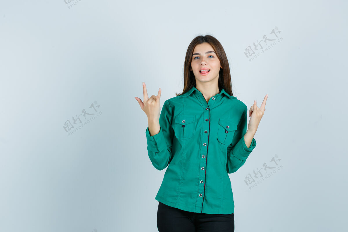 肖像展现摇滚姿态的年轻女性肖像 穿着绿色衬衫伸出舌头 看着快乐的前景人物姿势美国