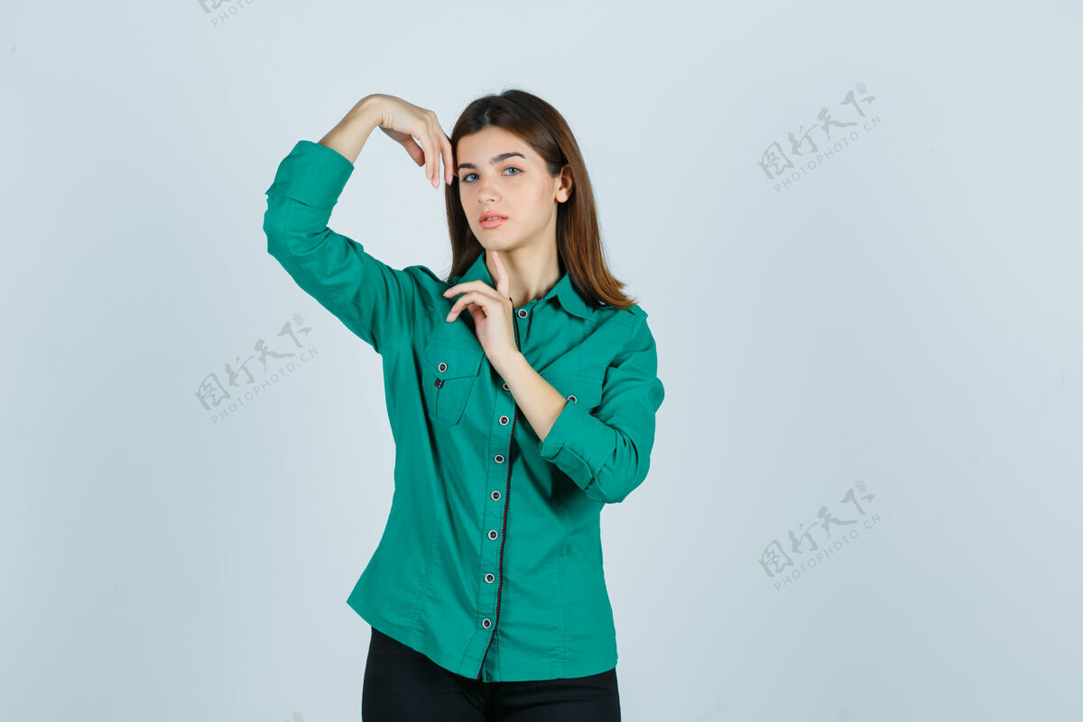 眼睛年轻的女性 手抱着头 穿着绿色衬衫 看起来很精致前视图姿势模特成人