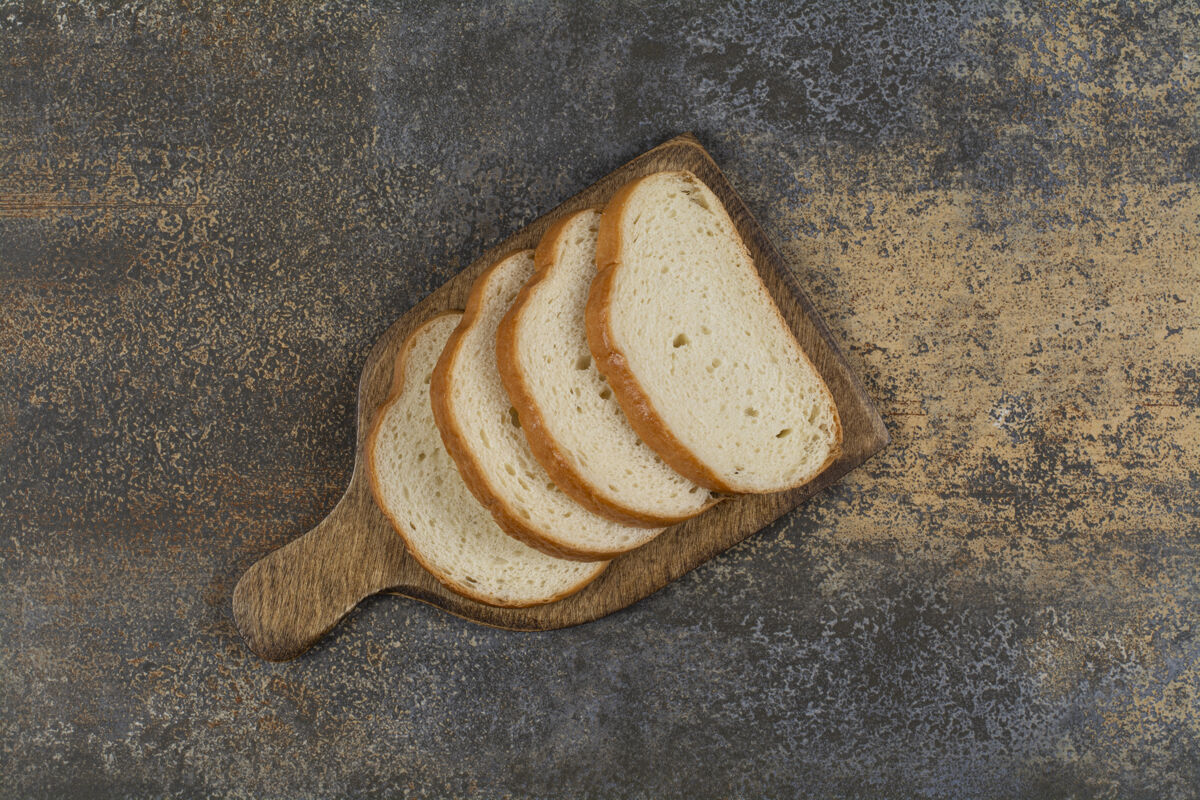 面包新鲜的切片面包放在木板上烘焙小麦食物