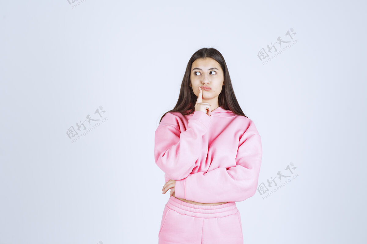 没有经验穿粉红色睡衣的女孩看起来既困惑又体贴人体模型员工计划