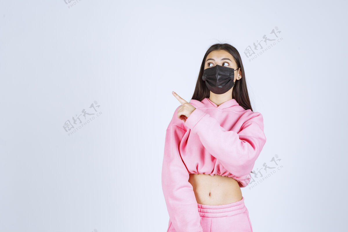呆在家里穿着粉色睡衣和黑色面具的女孩指着左边女性医学疾病