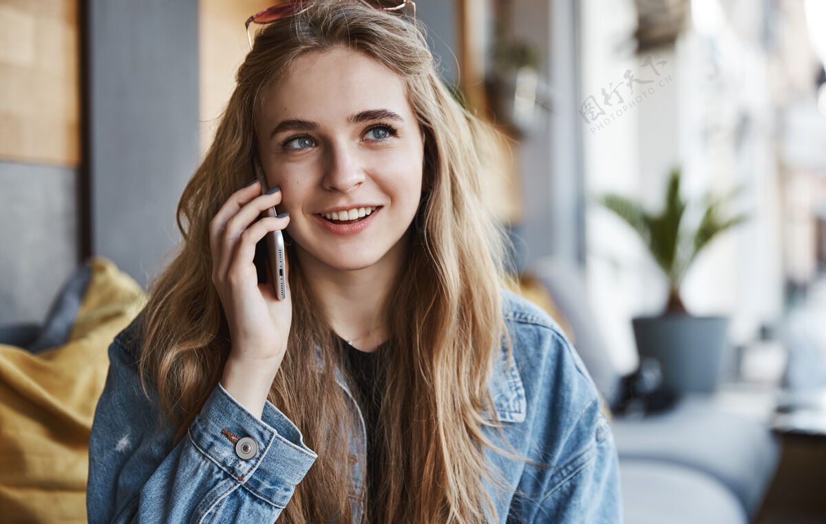 电话自然女孩坐在户外咖啡馆里聊天的画像饮料青年手机