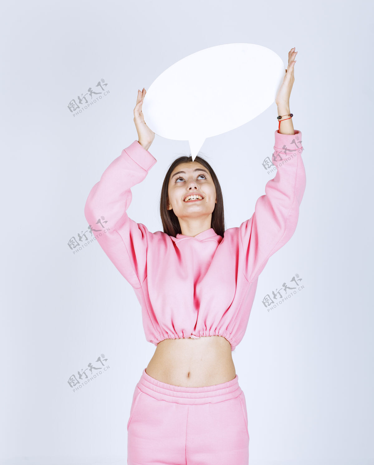 年轻穿着粉红色睡衣的女孩头上举着一个圆形的思考板成人人体模型工人