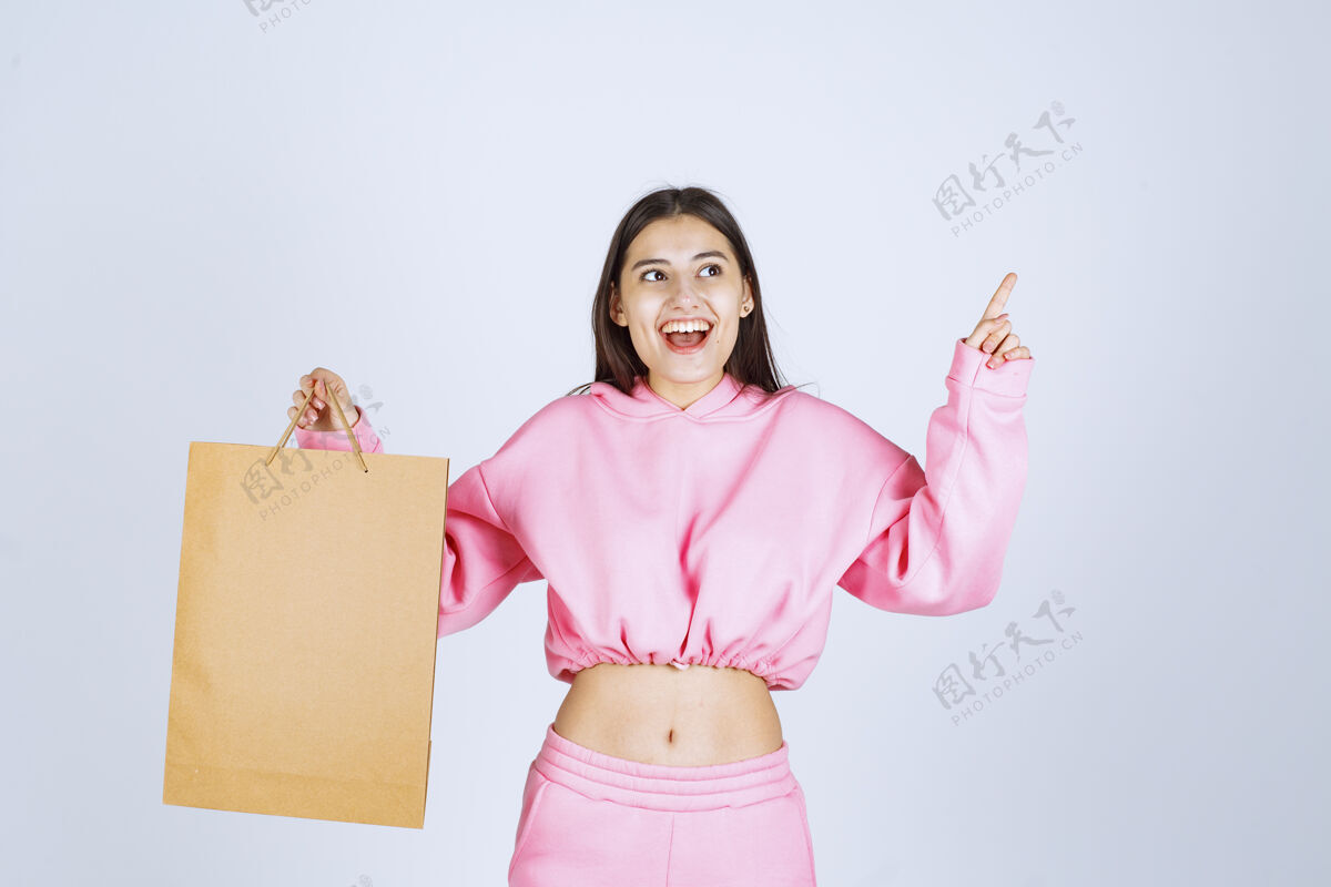 成人女孩拿着一个纸板购物袋 指着上面积极人人体模型