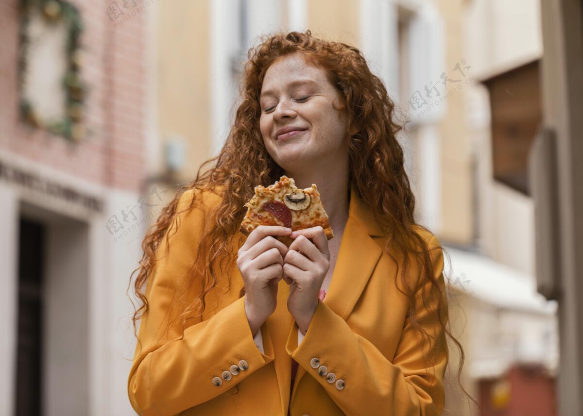 食物女人在户外吃街上的食物美味快餐小吃