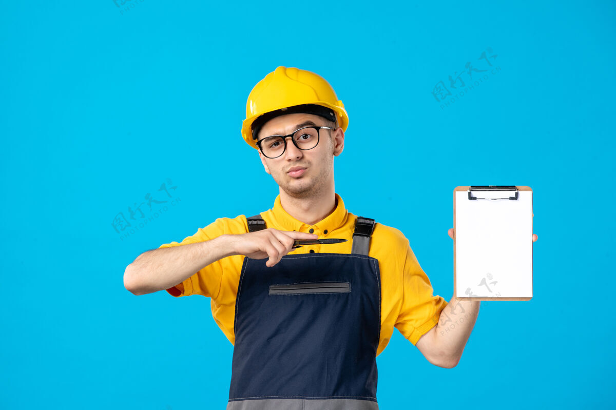 服务穿黄色制服的男工人的正视图在蓝色上制服帽子施工