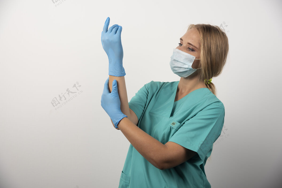 女医生戴着乳胶手套和医用口罩的女医生制服年轻医学