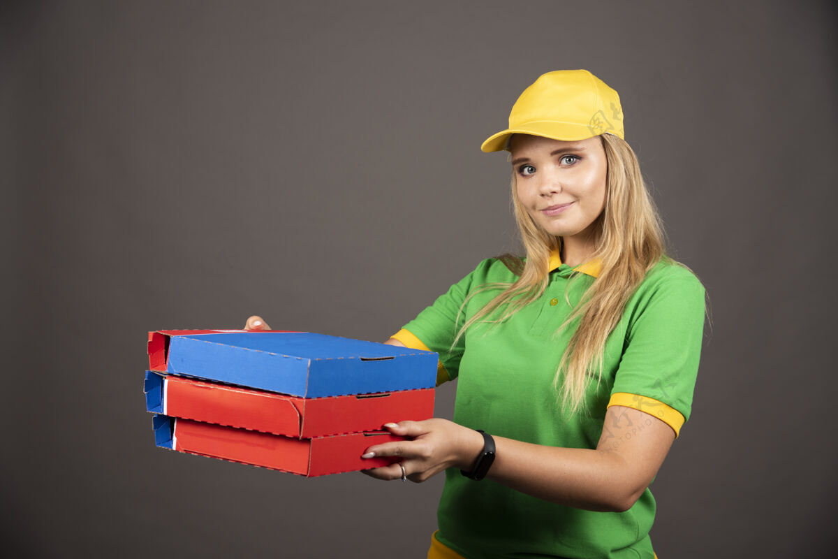 女士穿着制服拿着披萨纸板的女送货员制服工人服务