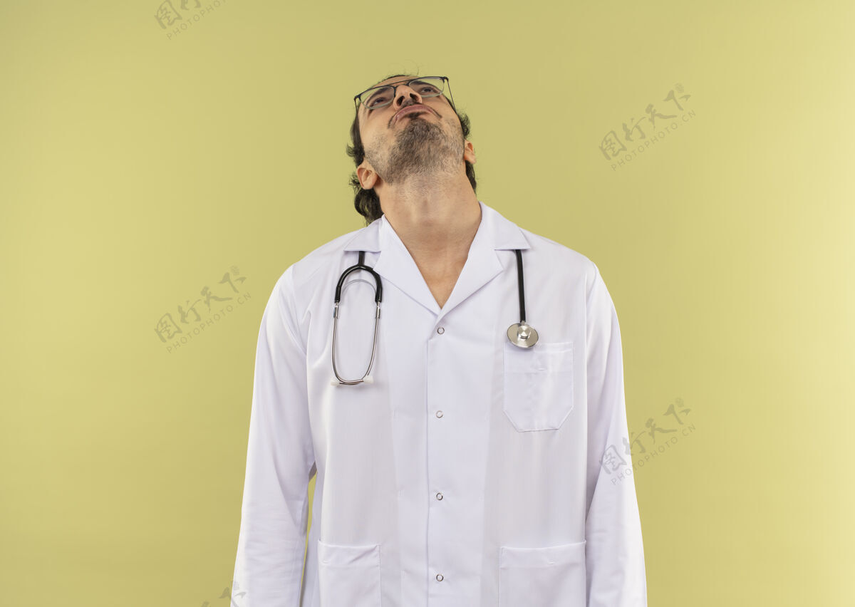 长袍仰望着戴着眼镜 穿着白袍 带着听诊器的年轻男医生男性听诊器光学