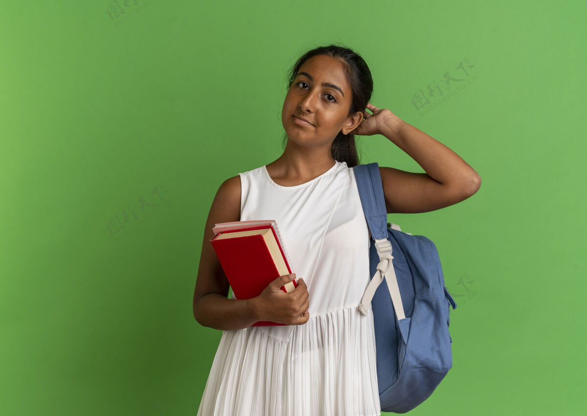 笔记本年轻的女学生背着书包 手里拿着笔记本 手放在头上年轻穿手持