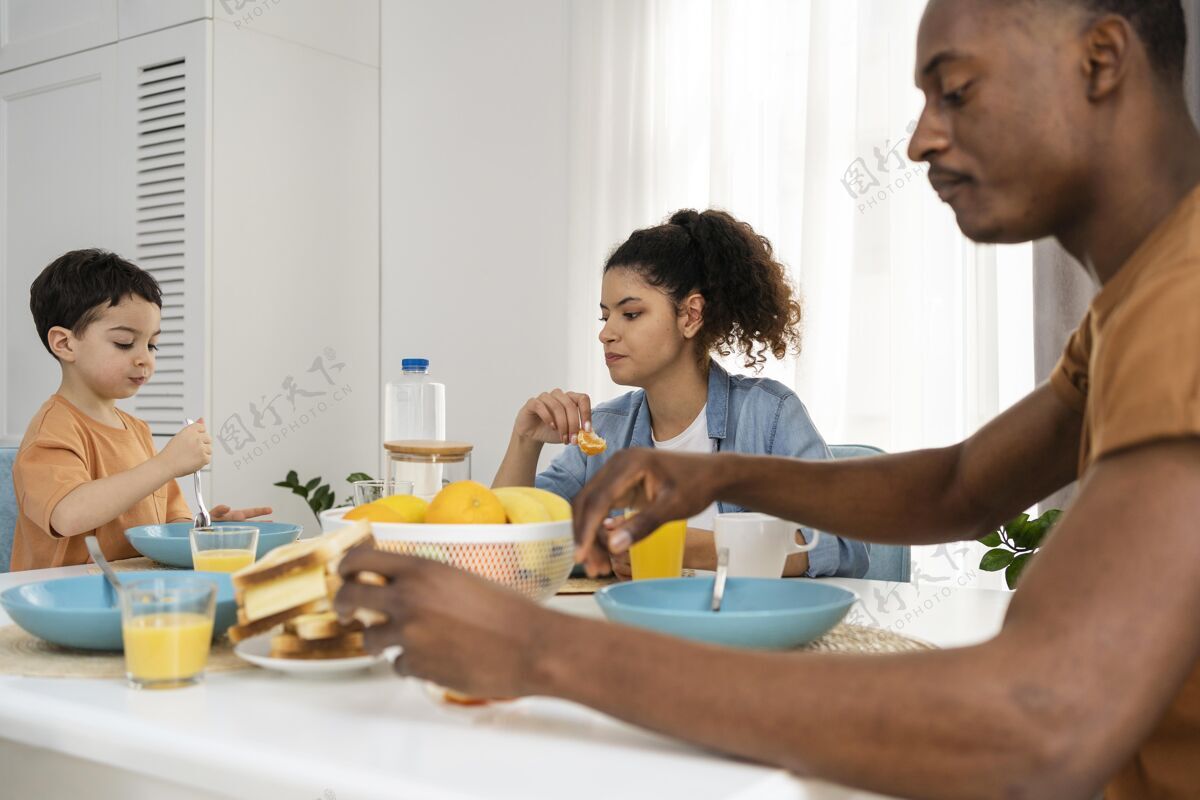 快乐的家庭可爱的小男孩和他的父母一起吃早餐优质时间孩子爸爸