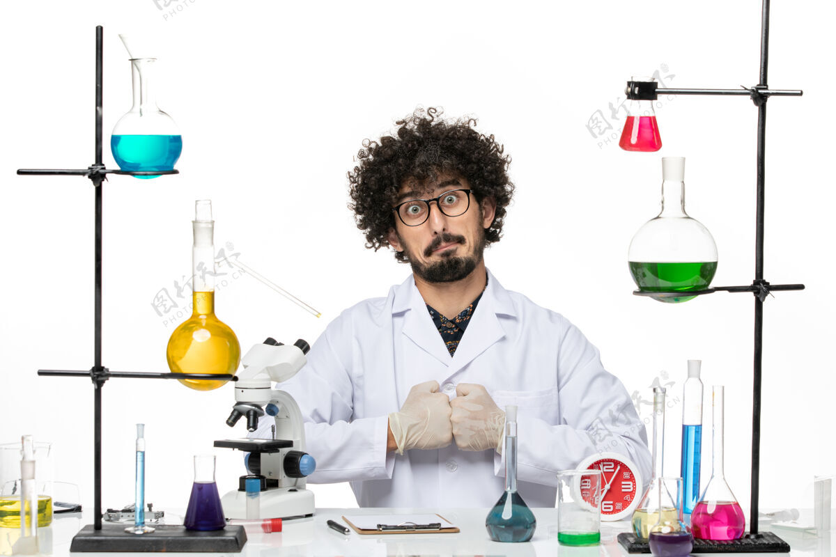 姿势前视图身着医疗服的男性化学家在空白处摆姿势西装科学实验室