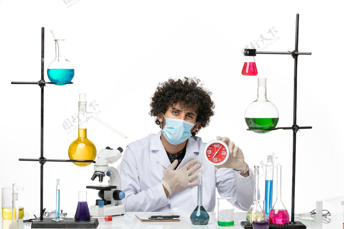 前面正面图：男药剂师 穿着医疗服 戴着面罩 在空白处拿着红色的时钟西装实验室时钟
