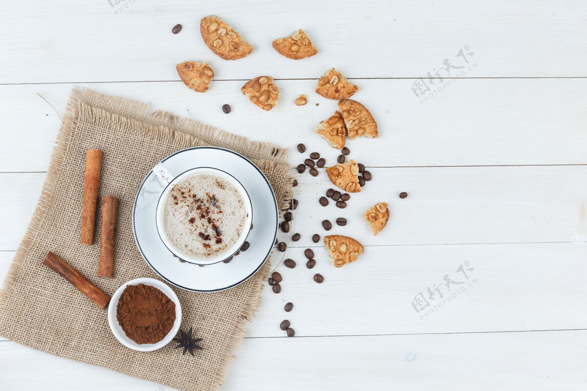 卡布奇诺顶视图咖啡杯咖啡豆 磨碎的咖啡 饼干 肉桂木棍和一块布袋背景水平水平咖啡因肉桂