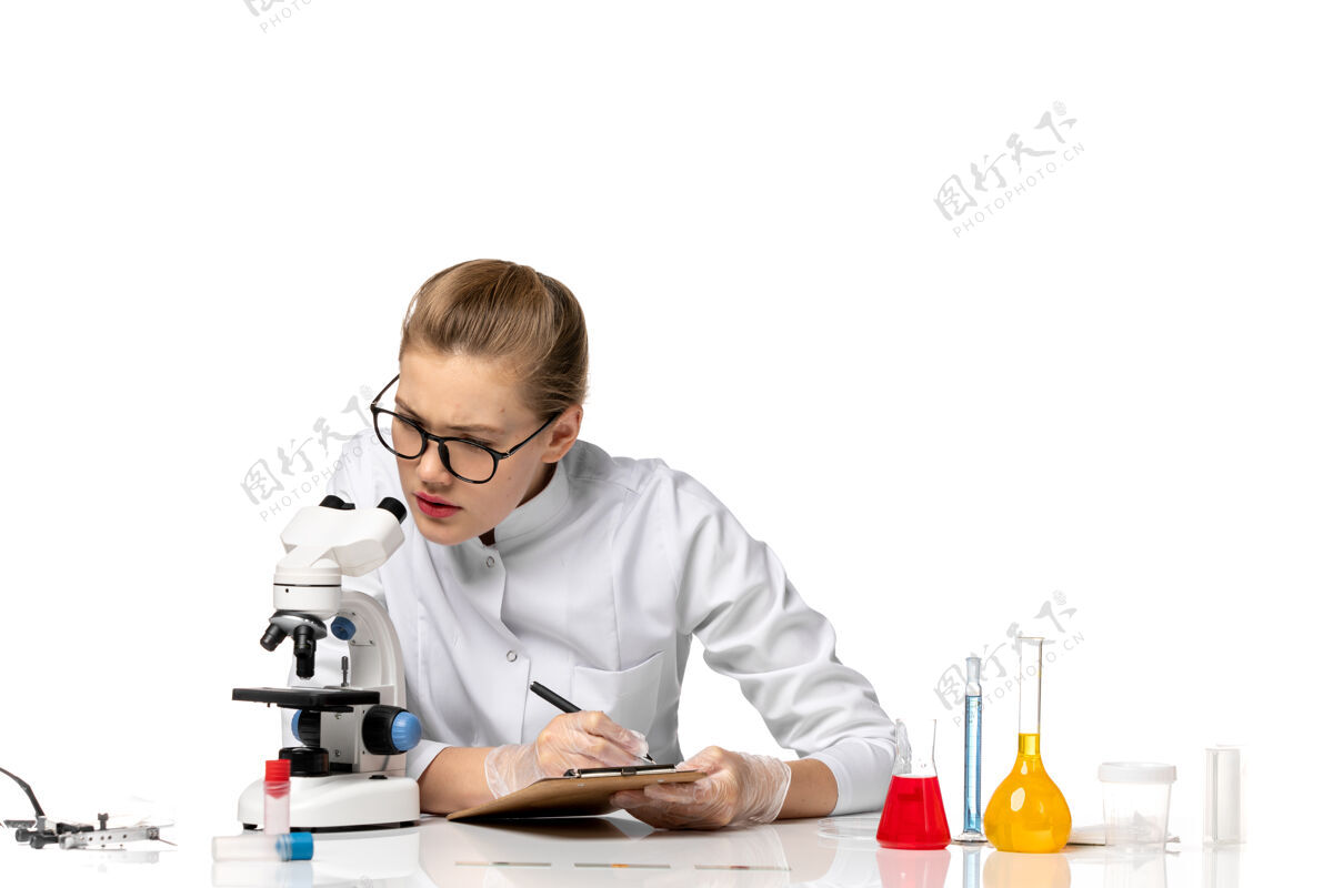 前台前视图穿着白色医疗服的女医生在白色空间里用显微镜工作秘书显微镜病毒