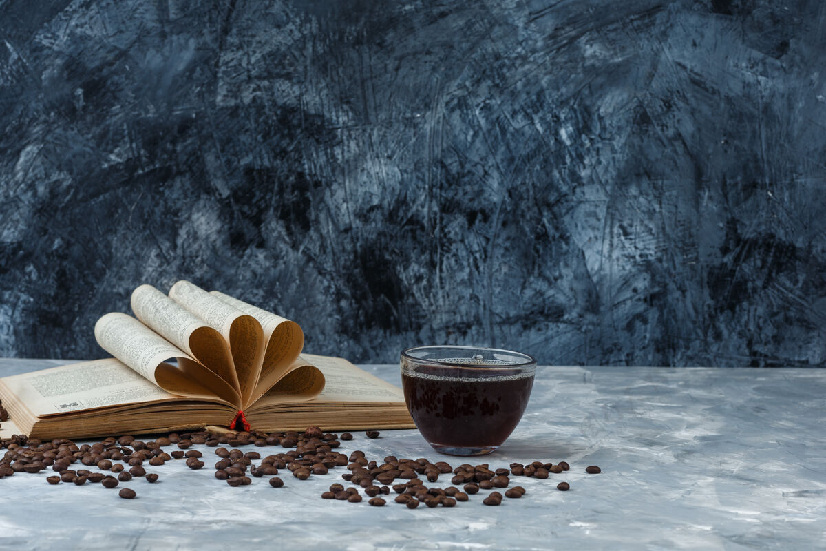 时间特写咖啡豆 咖啡杯与书上的浅蓝色和深蓝色大理石背景水平友谊大笑食物