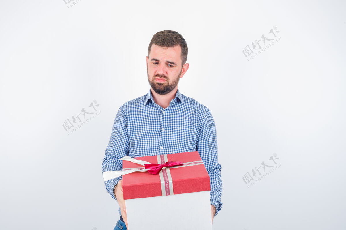 模特年轻的男人拿着礼物盒 看起来很失望 正面看时尚礼物严肃