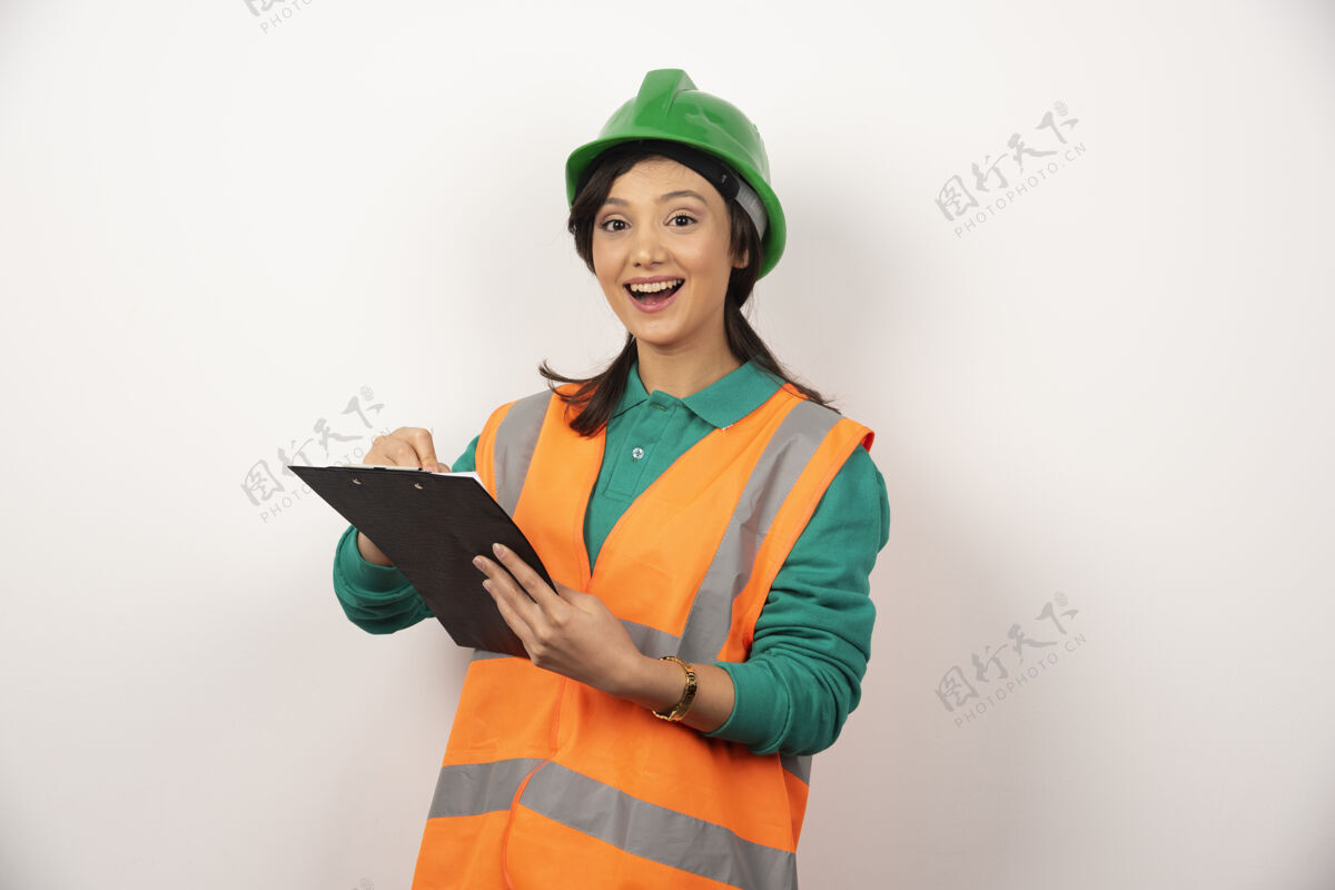 建筑工人积极的女性工业工程师制服与剪贴板上的白色背景女性安全帽工作
