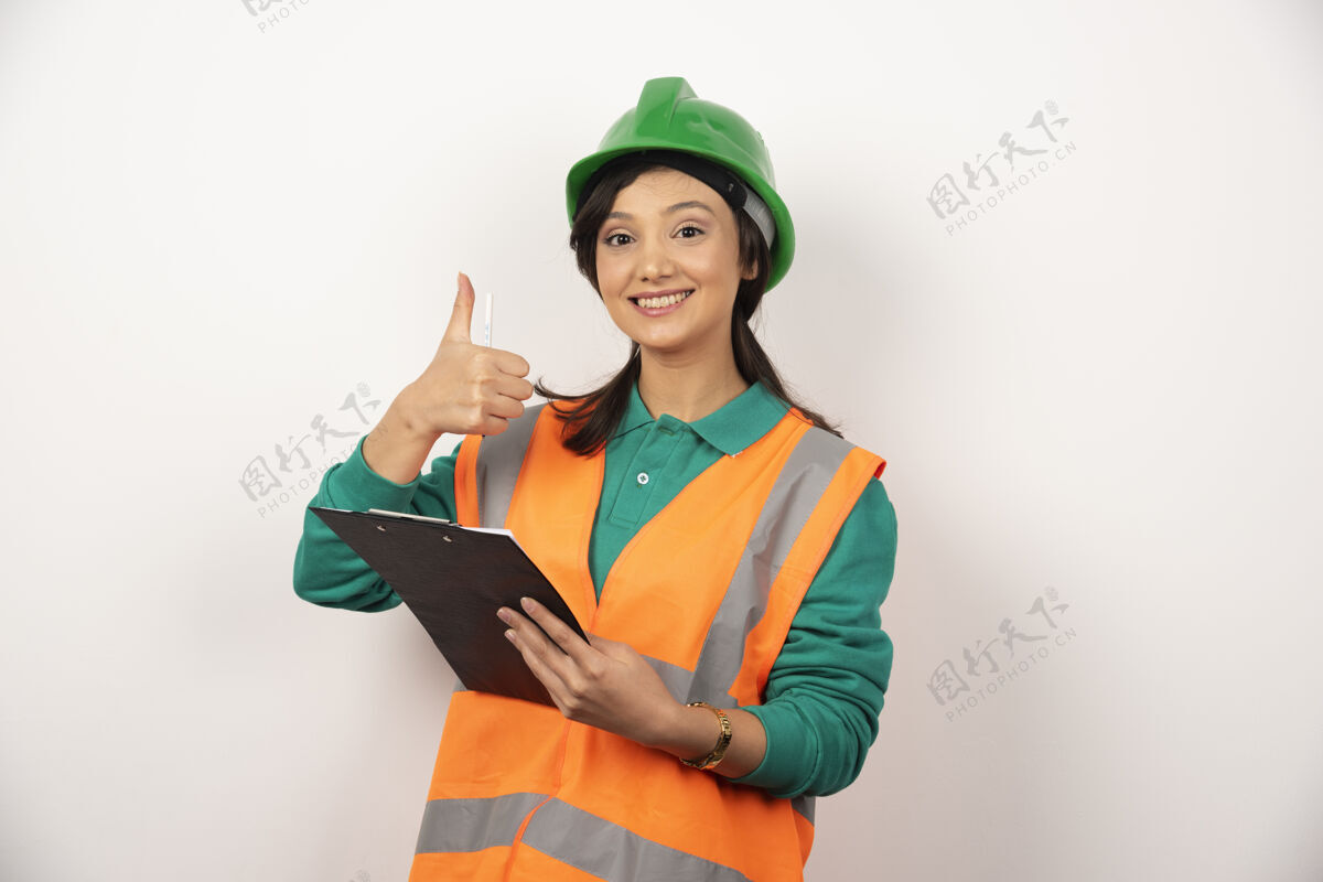 个人积极的女性工业工程师制服与剪贴板上的白色背景头盔工程师工作
