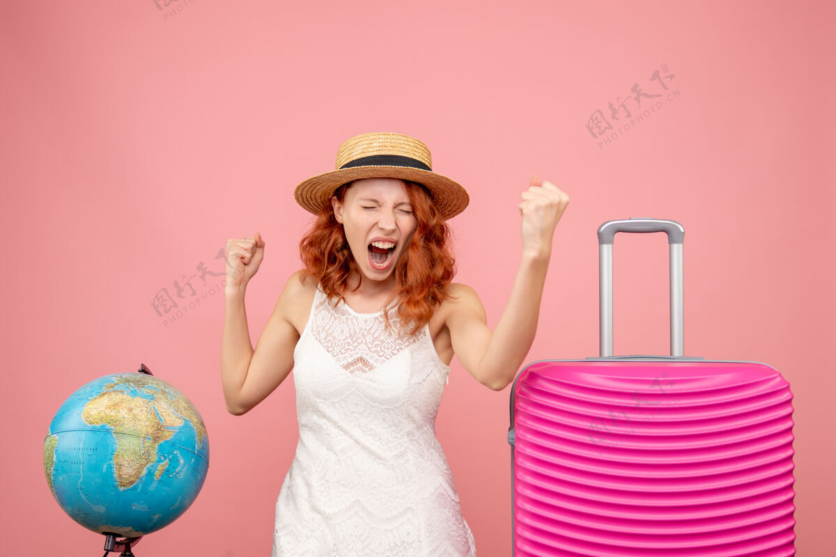 前面年轻女性游客的正面图 粉红色的墙上挂着粉红色的包包时尚旅行