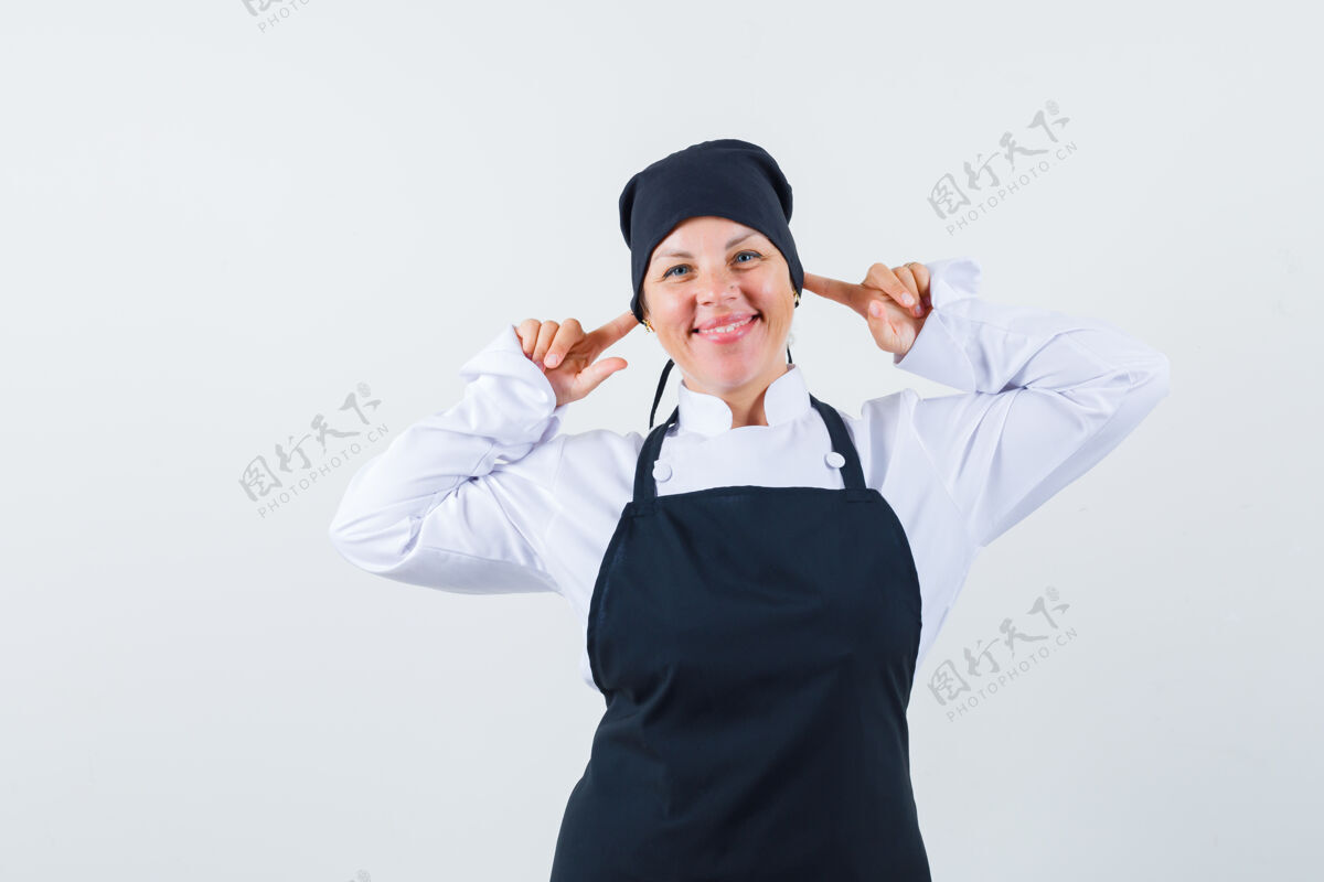 护理穿着黑色厨师制服的金发女人 用食指塞住耳朵 看起来很漂亮 正视图黑发亚洲人制服