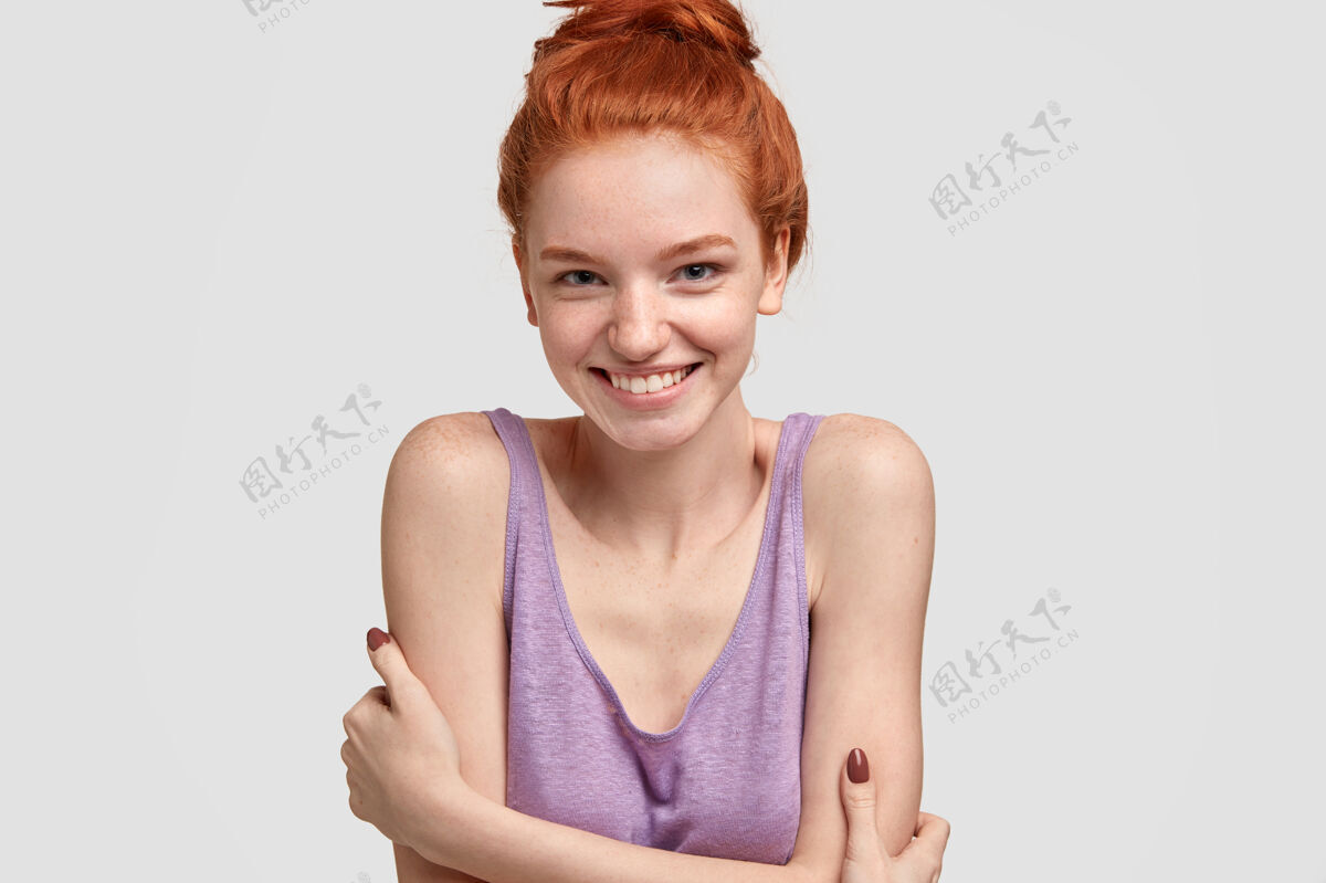 背心高兴害羞的女模特脸上有雀斑 红发梳成结 穿着休闲的大号衣服装束内容狐狸