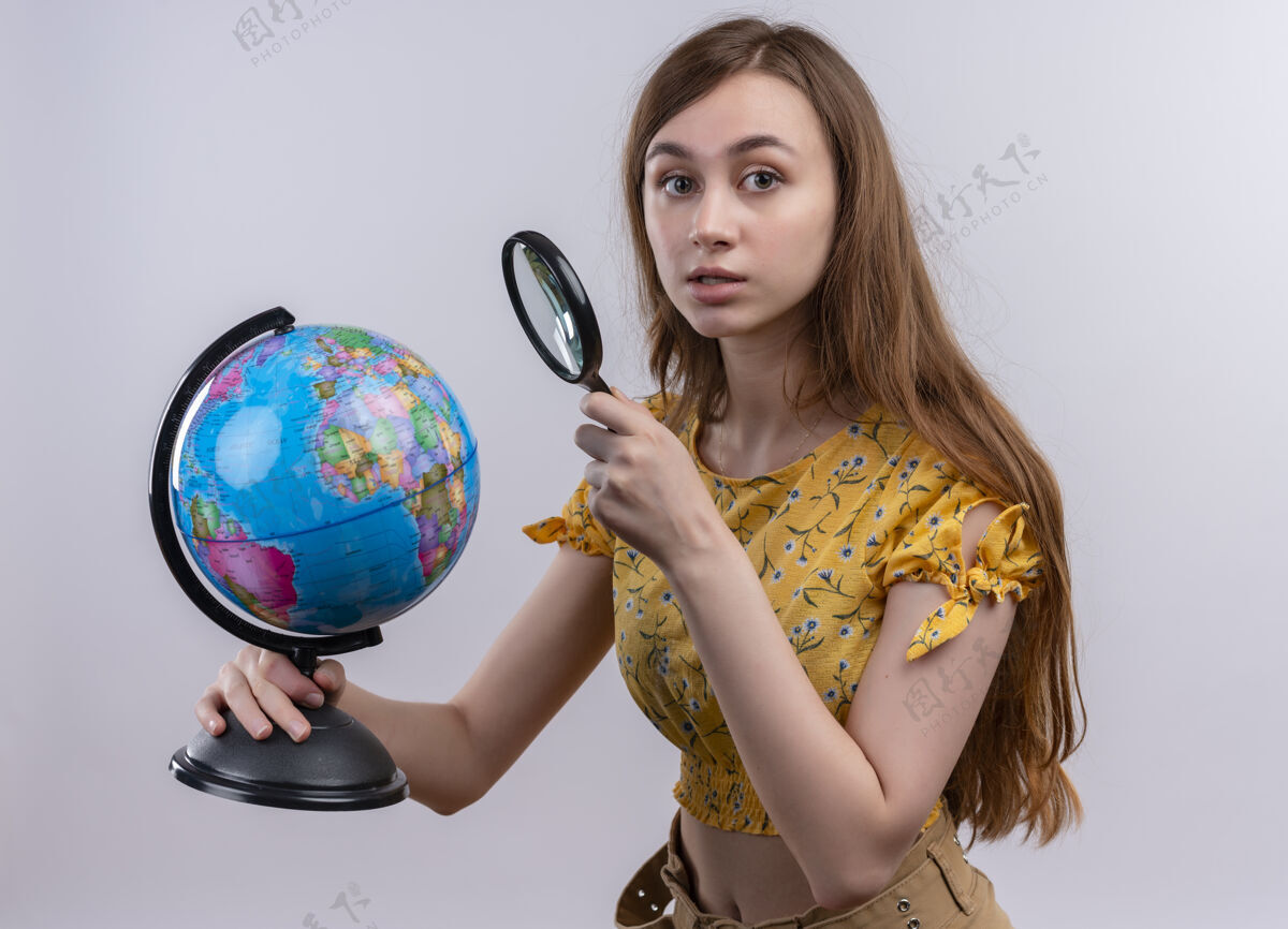 放大镜年轻女孩拿着地球仪和放大镜 看着孤零零的白墙地球仪女孩玻璃