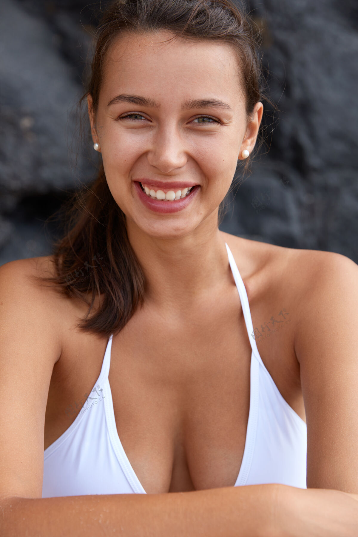 岩石快乐的女人 牙齿般的微笑 完美的胸部 看起来很高兴 穿着泳装健康海滩自由