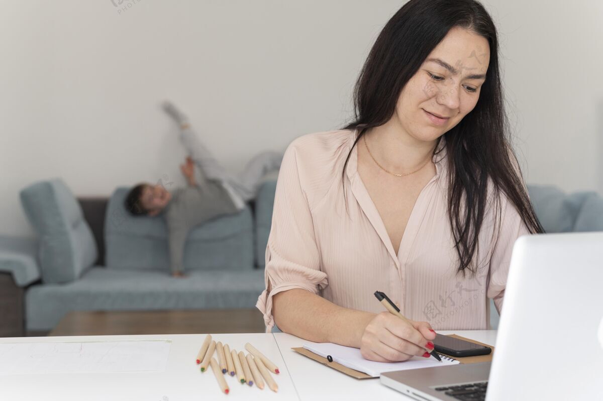 孩子中等身材的女人在家里用笔记本电脑工作工作童年笔记本电脑