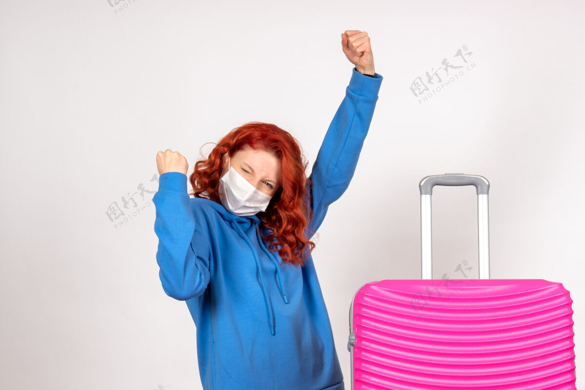 包戴着粉红色面具的年轻女性在白色墙壁上欢呼雀跃人航程前方