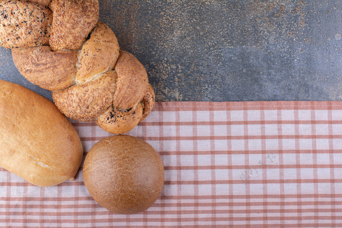 面包各式各样的面包放在大理石表面的桌布上各种面团各种