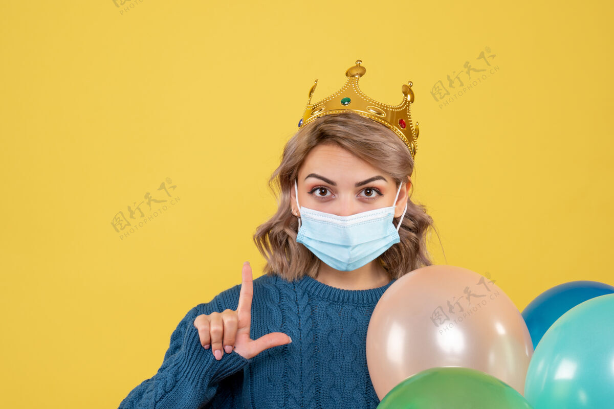 人年轻的女性拿着黄色的无菌面具气球医疗观点消毒