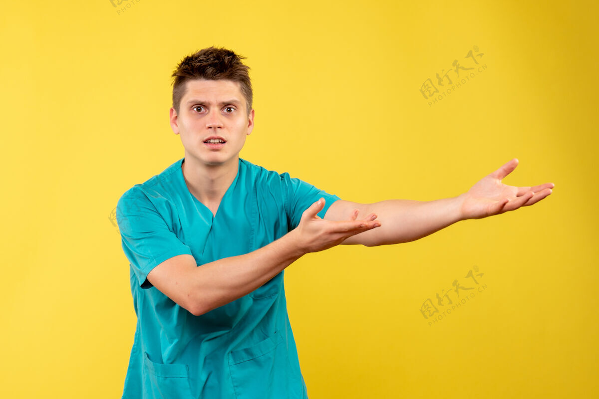 医院正面图黄色背景上穿着医疗服的年轻男医生背景西装成人