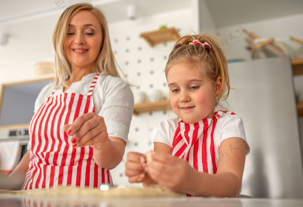 面粉可爱的金发女孩和妈妈一起快乐地做饭童年烹饪快乐