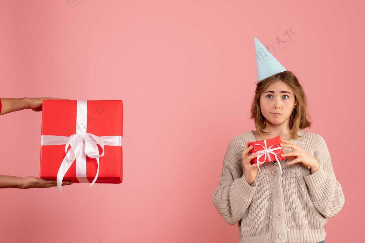 女人年轻的女性拿着圣诞礼物 接受粉色的男性礼物庆祝男粉红