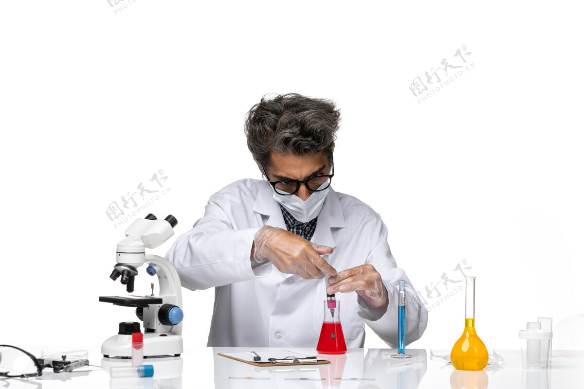 正面正面图身着白色医疗服的中年科学家正在用溶液填充注射剂科学注射实验室