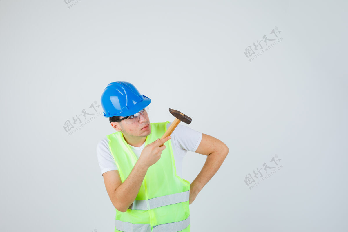 幼儿小男孩拿着锤子 手放在腰上 看着穿着建筑制服的锤子 目光集中前视图数字焦点房子