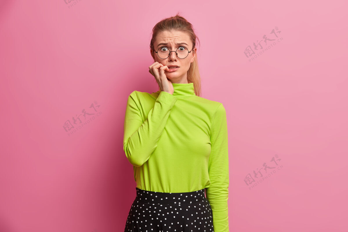 表情焦急焦急的欧洲女孩咬指甲害怕什么 有大问题 紧张 戴眼镜 绿色高领毛衣麻烦问题休闲