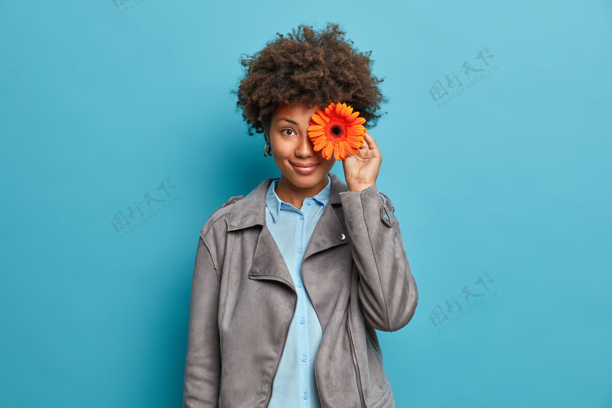 室内快乐快乐的年轻美籍女花匠做非洲菊花束 在花店工作 穿着灰色夹克 微笑愉快 调情灰色发型