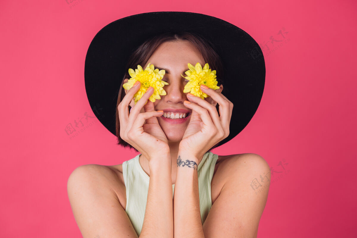 粉彩时髦的女人戴着帽子 脸上的笑容遮住了眼睛 带着黄色的紫苑 春意盎然 快乐的情感与世隔绝节日黄色年轻