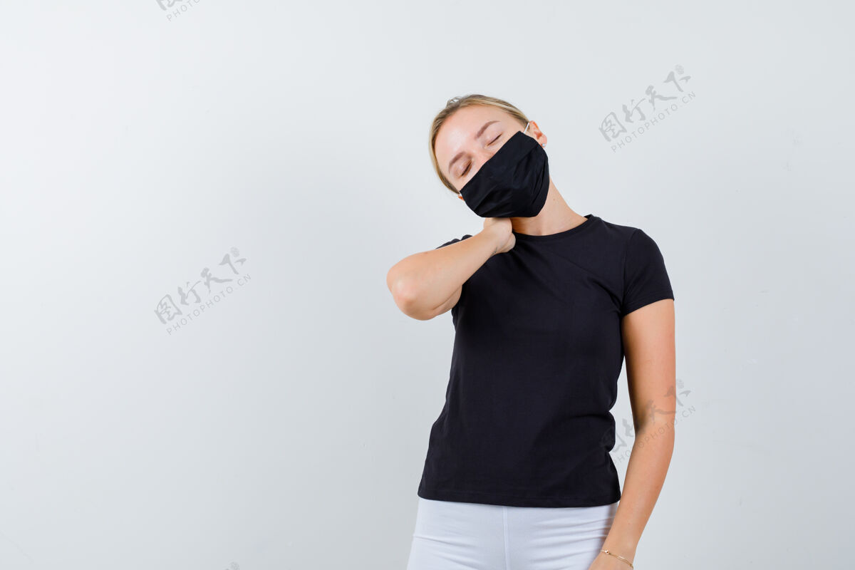 女性身穿黑色t恤的年轻女士 戴着口罩忍受着颈部疼痛 看上去很疲惫 前视图皮肤面具成人