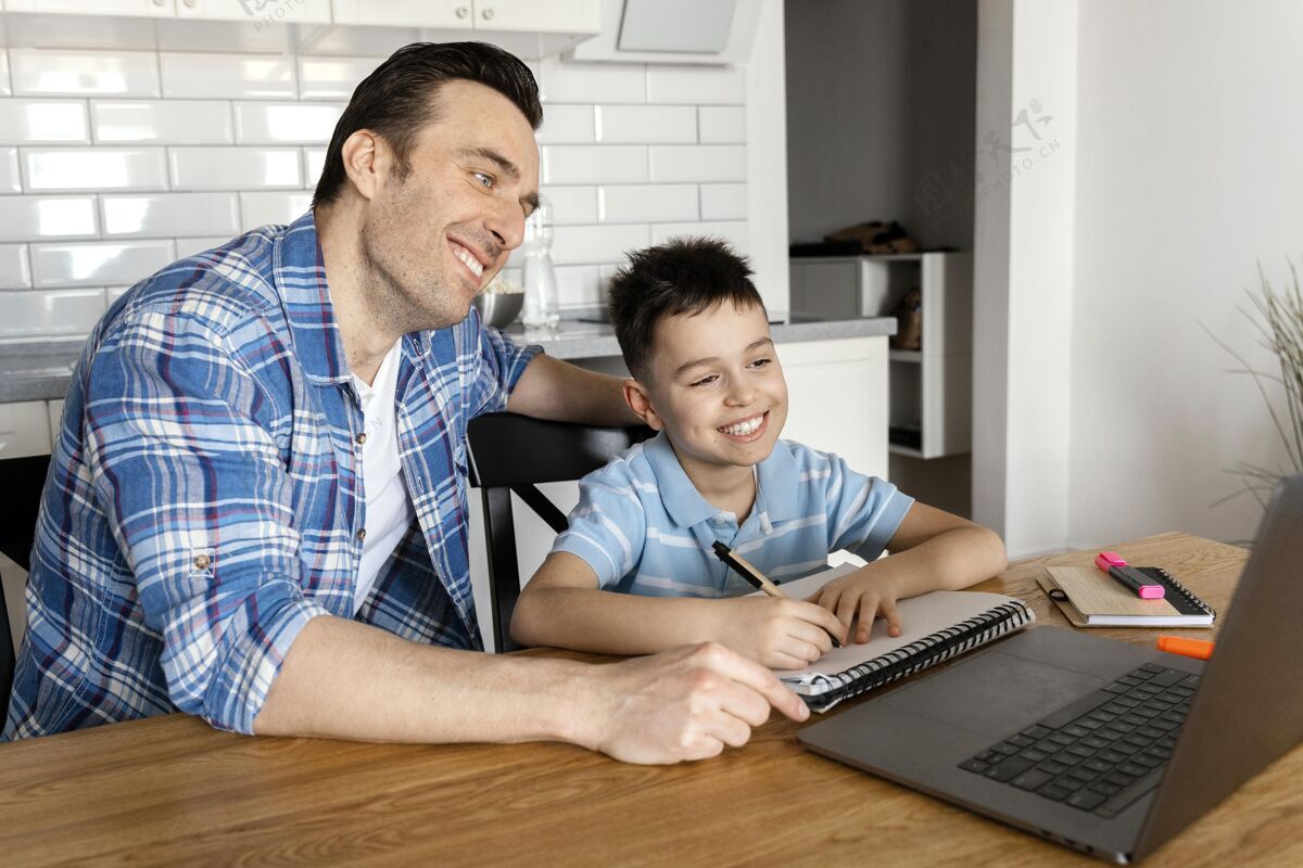 孩子中枪的爸爸和男孩拿着笔记本电脑在家里男人水平