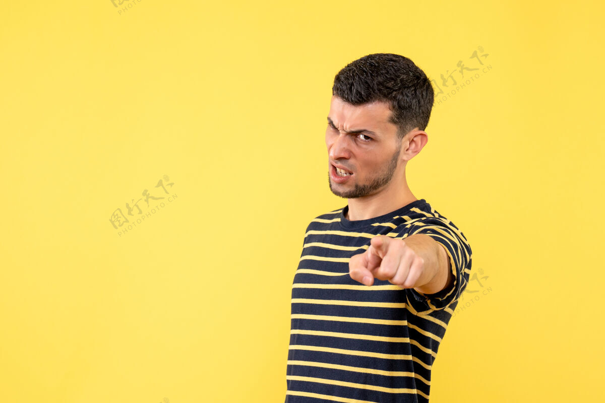 黑正面图愤怒的年轻男性穿着黑白条纹t恤黄色隔离背景T恤男白