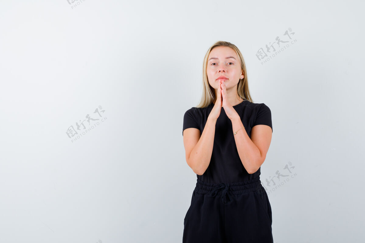 年轻身穿t恤 裤子的年轻女士手牵手祈祷 看上去充满希望 正面照女性女孩手势