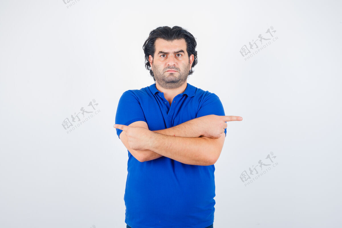 抱着穿蓝色t恤 牛仔裤的成熟男人双臂交叉 食指指向相反的方向 看起来很生气 前视图方向沮丧攻击性