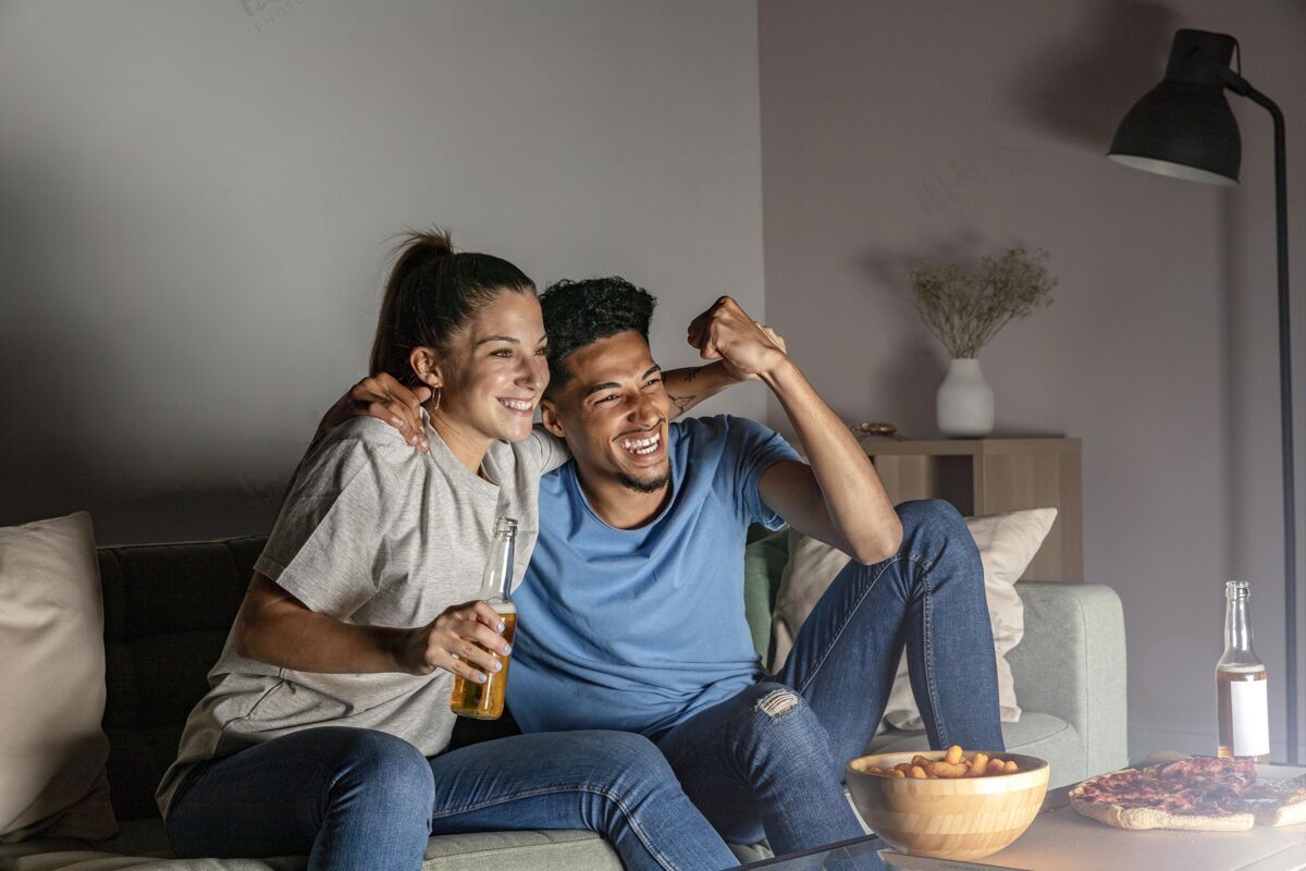 足球比赛男人和女人在家喝啤酒 一边看电视 一边吃零食人足球比赛足球比赛